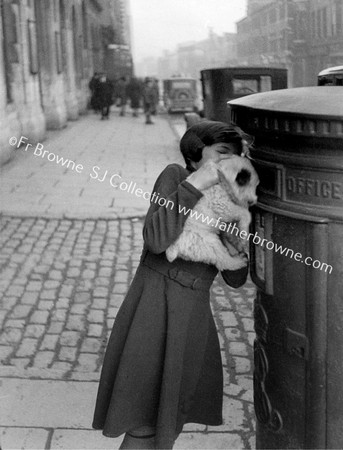 GIRL WITH PUPPY AT PILLAR BOX